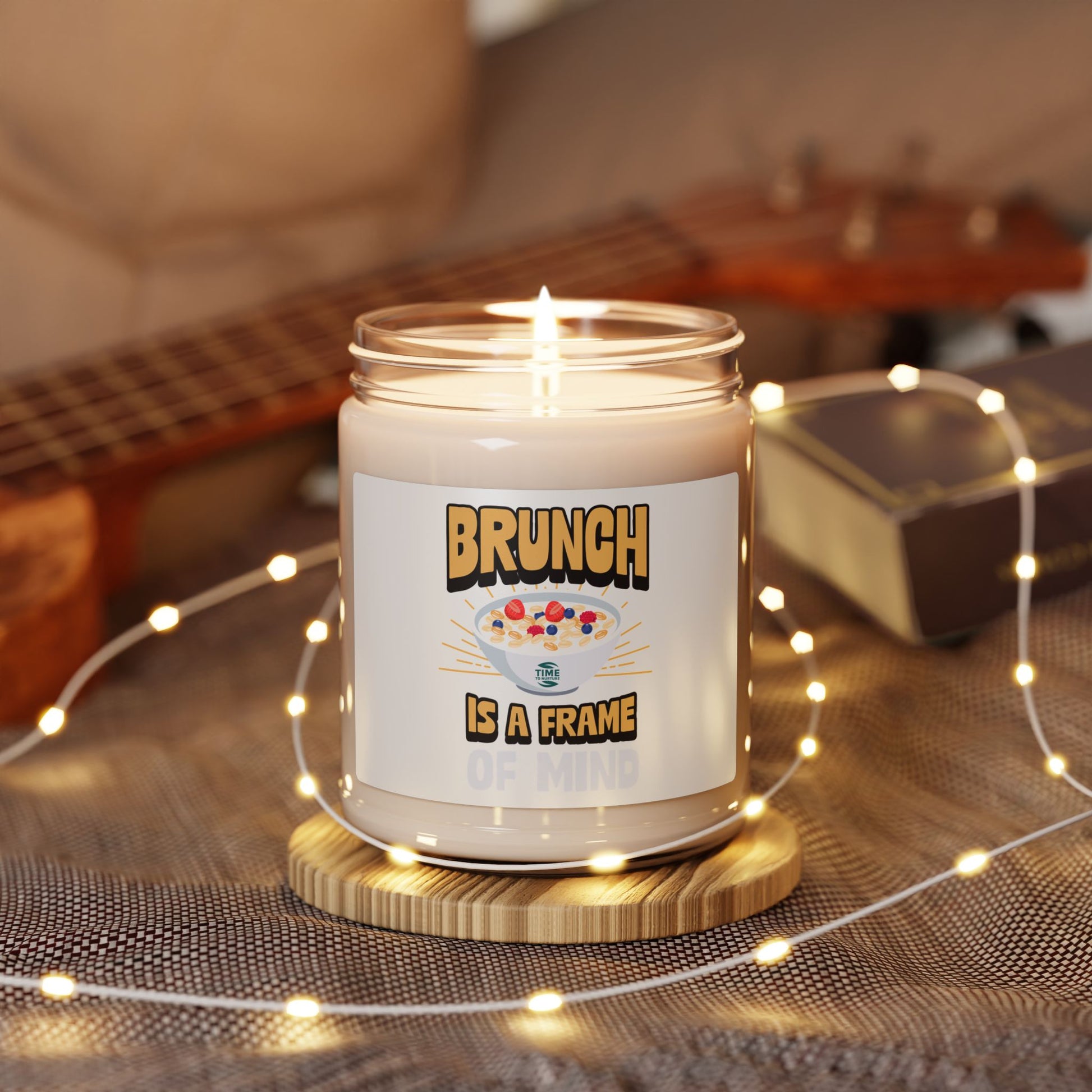 A "Brunch Is a Frame of Mind" scented soy candle in a stylish amber glass jar. The 9oz candle features natural soy wax, a cotton wick, and a long burn time, offering inviting aromatic scents for a cozy ambiance and relaxation.