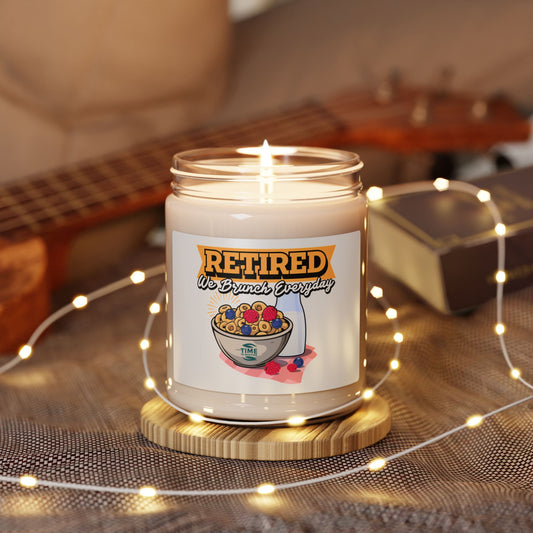 9oz amber jar candle with a cotton wick, labeled 'Retired, We Brunch Everyday.' The candle features a natural soy wax blend and cozy aromatic scents designed for relaxation and ambiance.