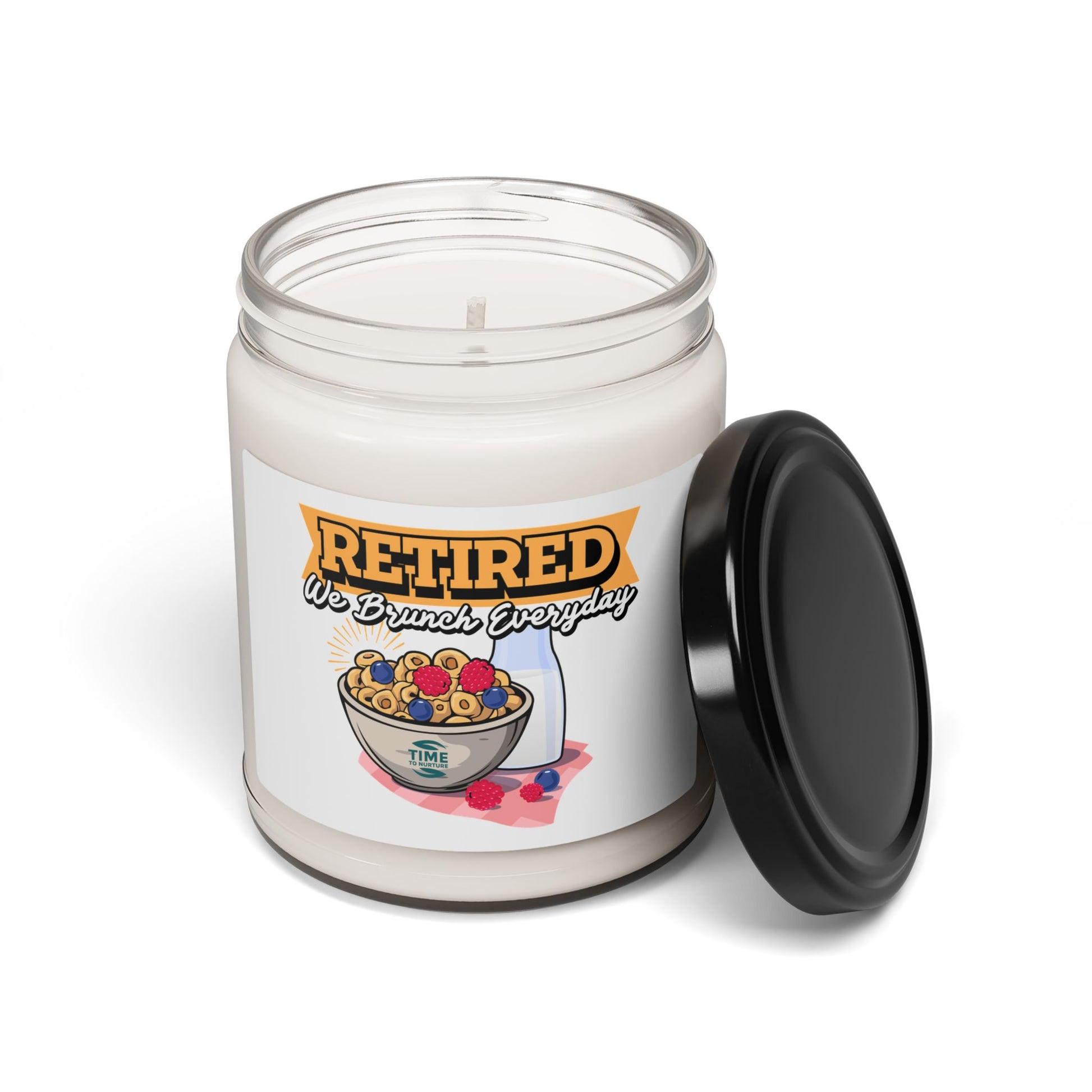 9oz amber jar candle with a cotton wick, labeled 'Retired, We Brunch Everyday.' The candle features a natural soy wax blend and cozy aromatic scents designed for relaxation and ambiance.